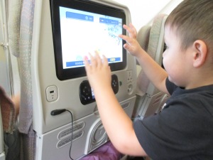 Micah playing with his in-flight entertainment monitor. He loved the Winnie the Pooh video games!
